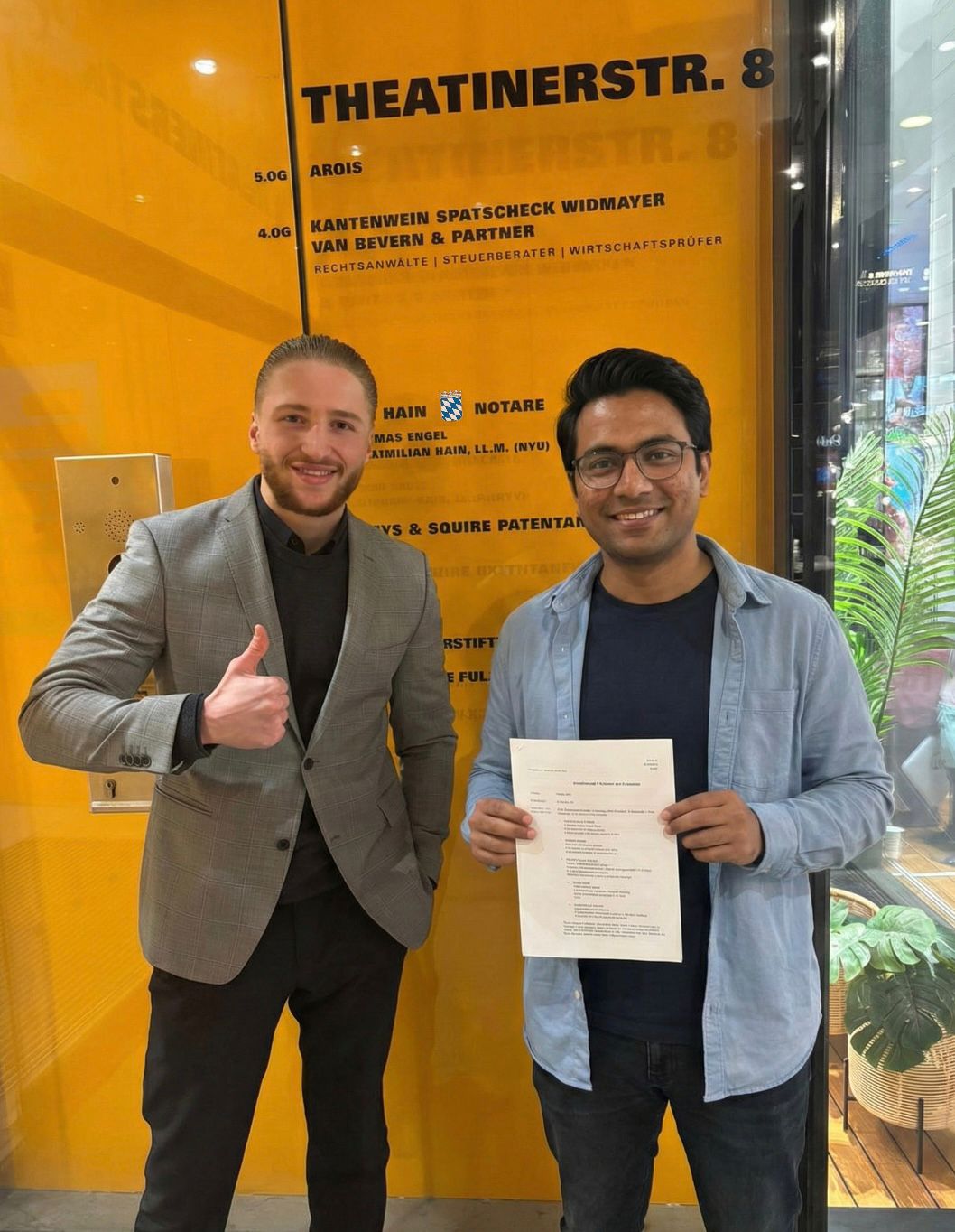 Client holding signed Kaufvertrag with Moderna advisor at Munich notary, Theatinerstr. 8